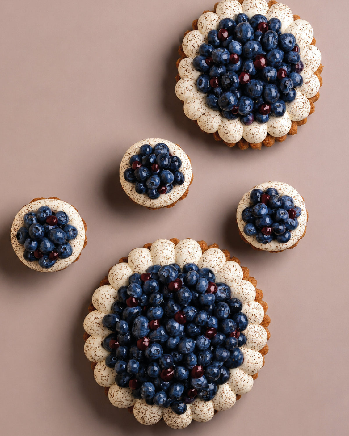 Cupcakes with blueberry toppings on a brown background